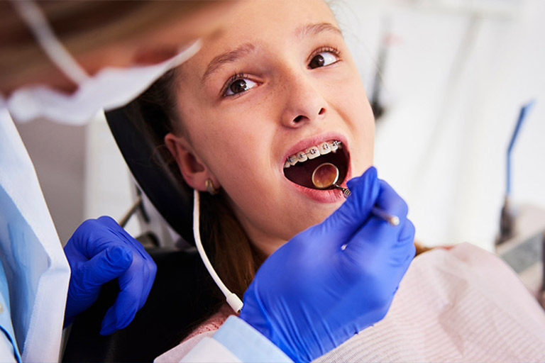Ortodoncia, niña en una clinica dental