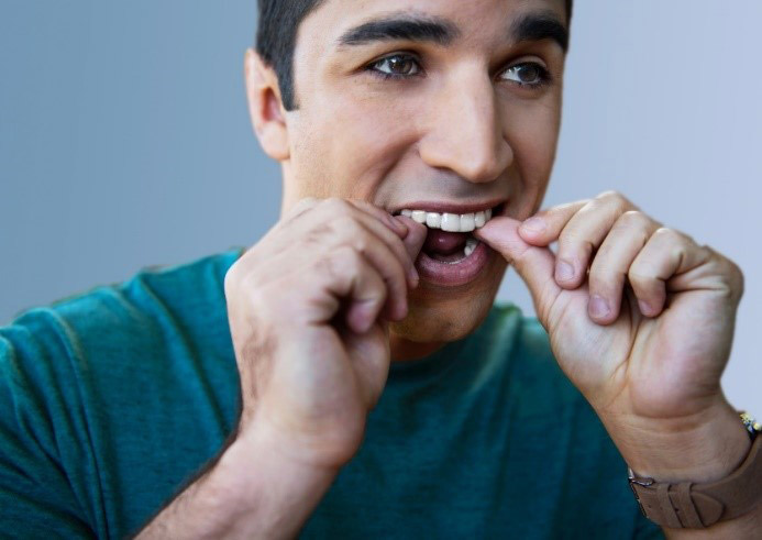 Hombre tocandose los dientes Blanqueamiento dental