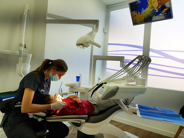 odontologa de Clinica Verona antendiendo a un paciente infantil